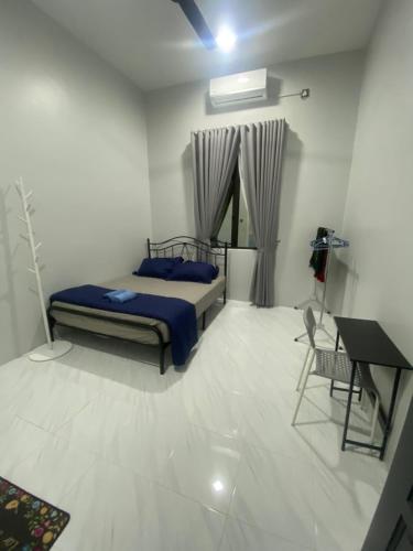 a bedroom with a bed and a desk in it at Permai Homestay in Kampong Burok