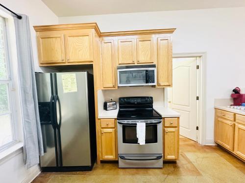 a kitchen with stainless steel appliances and wooden cabinets at Chateau 6 in Hammond