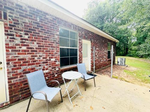 two chairs and a table in front of a brick building at Chateau 6 in Hammond