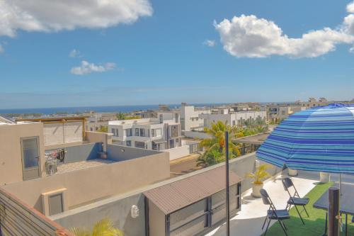 a view of a city from a balcony with an umbrella at Cozy Garden 5 Apartment F1 in Flic-en-Flac