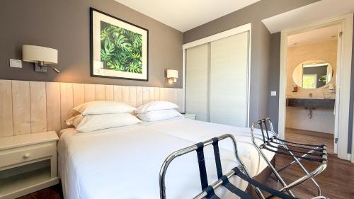a bedroom with a large white bed with a chair at AP Adriana Beach Resort in Albufeira