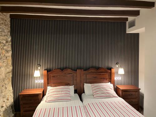 a bedroom with a large bed with two night stands at Casanova de Baix in Ripoll