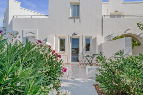 a white house with a courtyard with plants at Almyra Resort in Koutsounari