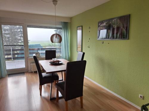 a dining room with green walls and a table and chairs at Ferienwohnung Würzberg - Odenwald in Michelstadt