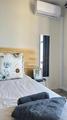 a bedroom with a white bed with a wooden headboard at Modern Ocean-View Apartment in Durban