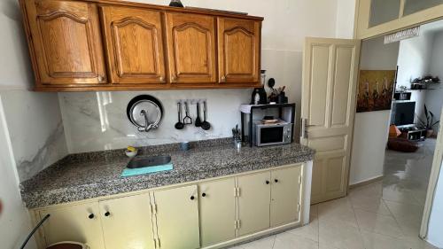 a kitchen with wooden cabinets and a counter top at Chambre privée au cœur de Rabat in Rabat