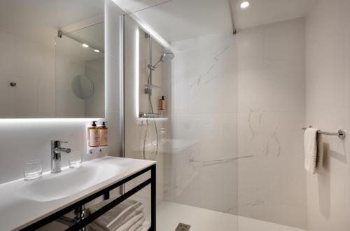 a white bathroom with a shower and a sink at Mercure Montpellier Centre Antigone in Montpellier
