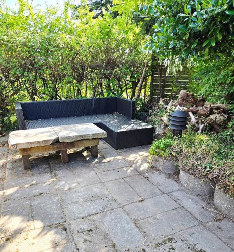 a bench and a table on a patio at Irenes Anneks in Nyborg