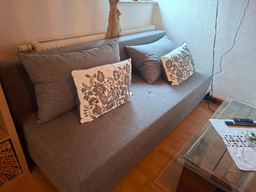 a couch with pillows on it in a living room at ansimali 3 - Treffpunkt Dachgeschosswohnung, Ideal für Familien und Freunde, Gemeinsam wohnen, getrennt träumen, Zwei Schlafzimmer, ein Urlaub mit Spiel und Spaß in Grünhain-Beierfeld