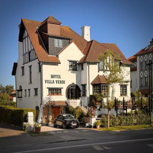 a building with a car parked in front of it at Hotel Villa Verdi in Knokke-Heist