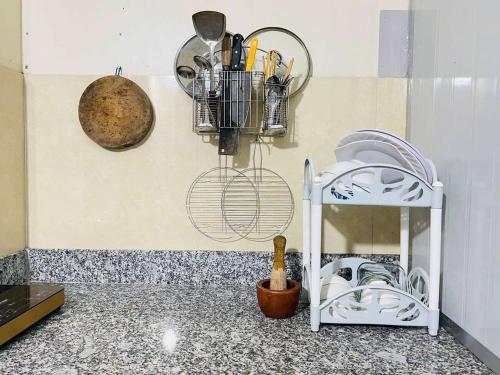 a kitchen with a counter with utensils on the wall at KYNA-Breakfast, near pier, private entrance in Rach Gia