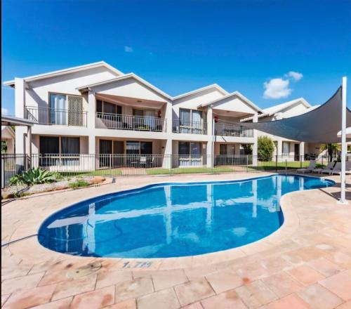 a swimming pool in front of a house at Pelican Shore Villa 2 - Kalbarri WA in Kalbarri