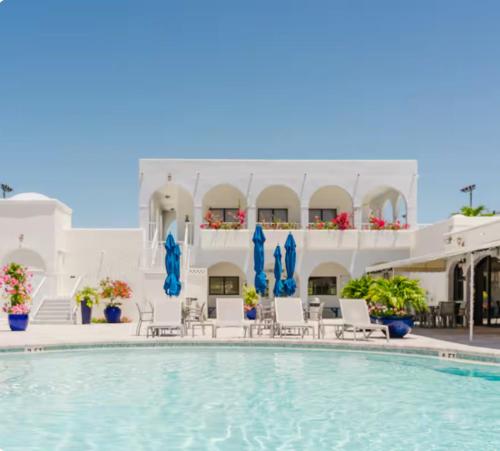 a pool in front of a building with chairs and umbrellas at Naples Dream at WTC with Heated Pool SPA Sauna 7 bicycles and 3 mls to beach in Naples