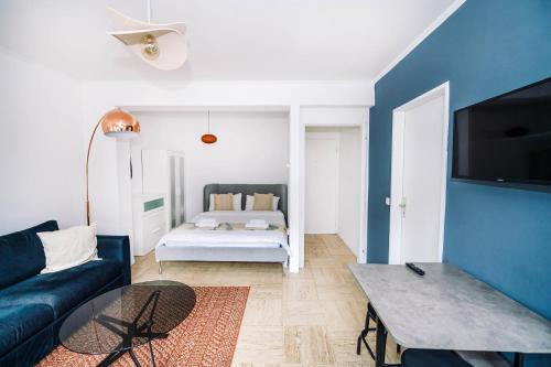 a living room with a couch and a blue wall at Studio in City Centre Lux in Luxembourg