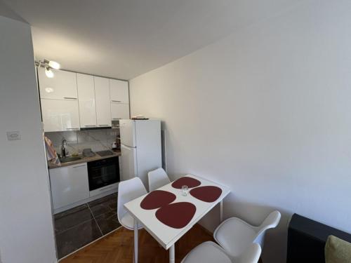 a small kitchen with a white table and white chairs at Micho Apartment in Ohrid