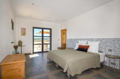 Un dormitorio con una cama grande y un balcón. en La colle aux sources, en Esparron-de-Verdon