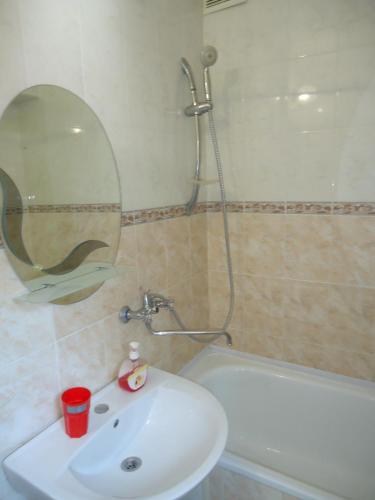 a bathroom with a sink and a mirror and a tub at Гостевой дом у моря in Odesa