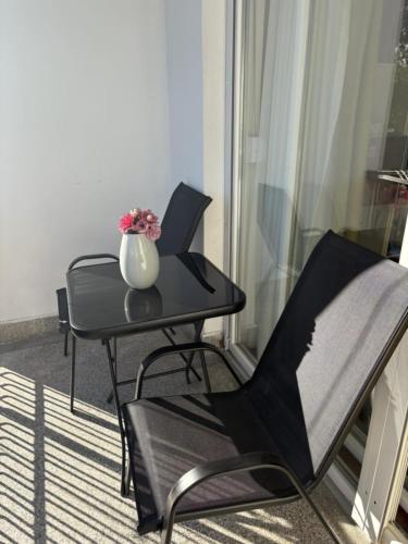 a table and chairs with a vase on top of it at Micho Apartment in Ohrid