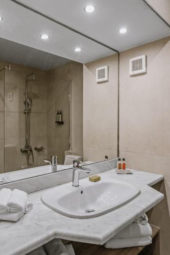 a bathroom with a sink and a shower at Almyra Resort in Koutsounari