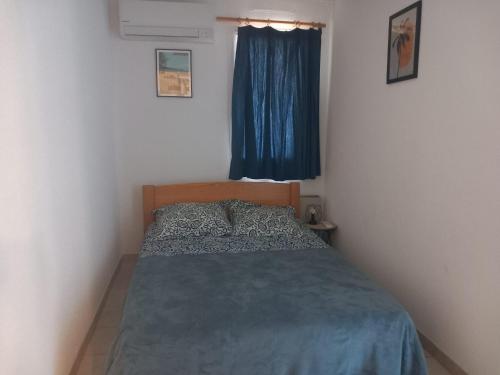 una camera da letto con un letto con un piumone blu e una finestra di agreable appartement proche plages a Bormes-les-Mimosas