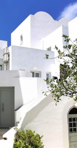 a white building with stairs in front of it at New Haroula in Fira