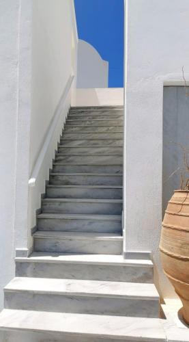 a staircase leading up to a white building with grey steps at New Haroula in Fira