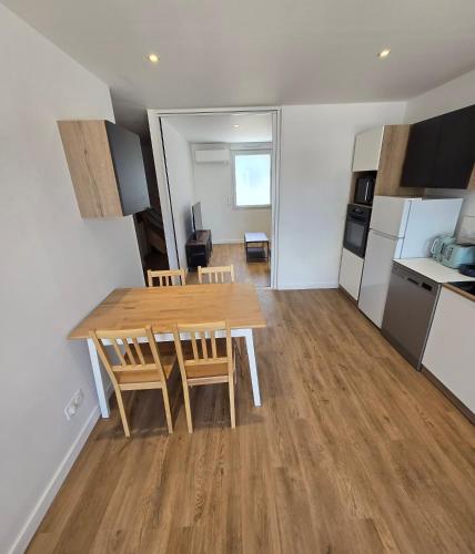 a kitchen and dining room with a wooden table and chairs at Gites des ammonites 2 in Montalieu-Vercieu