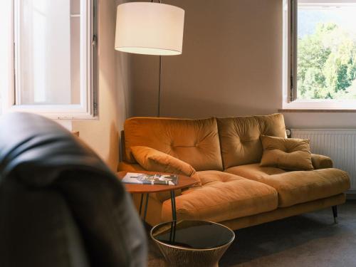 a living room with a brown couch and a table at The Townhouse Ruhpolding - Individual Design & Casual Concept in Ruhpolding