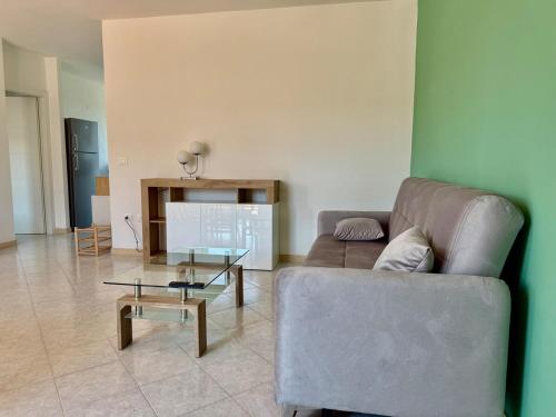 a living room with a couch and a glass table at Torrenieri House in Torrenieri