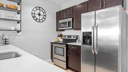a kitchen with a stainless steel refrigerator and cabinets at Spacious 2 bd-2 ba in the Heart of Asbury Ave in Ocean City