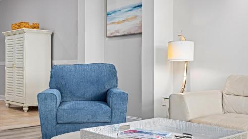 a living room with a blue chair and a couch at Spacious 2 bd-2 ba in the Heart of Asbury Ave in Ocean City