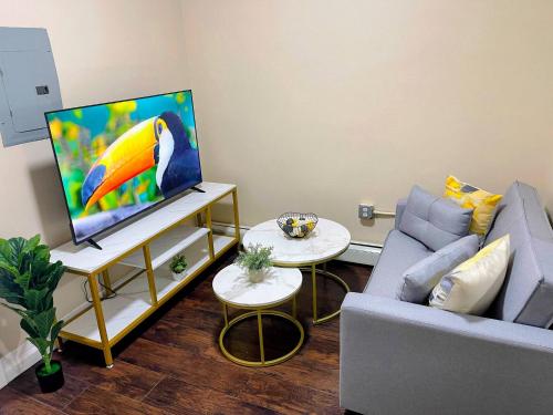 a living room with a couch and a tv at Cozy 2BR Brick Haven! Near light rail! 35m to NYC in Jersey City