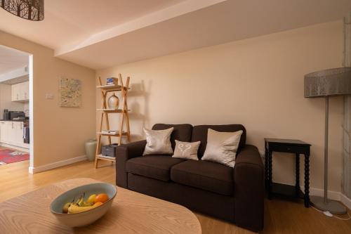 a living room with a couch and a bowl of fruit on a table at The Highland Club in Fort Augustus