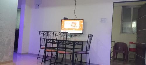 a room with a table with chairs and a tv at The Grand Sulochana Banglow Bhilar 101 in Mahabaleshwar