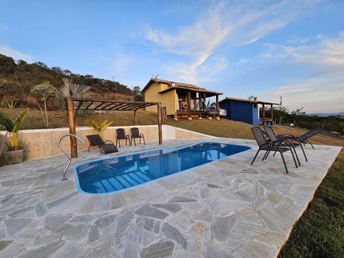 Kolam renang di atau dekat dengan Chalés Vila Real - Tranquilidade na Serra de Carrancas - Piscina com uma vista espetacular do Pôr do Sol