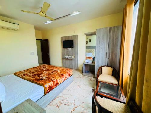 a bedroom with a bed and a chair and a tv at Hotel tree inn in Zirakpur