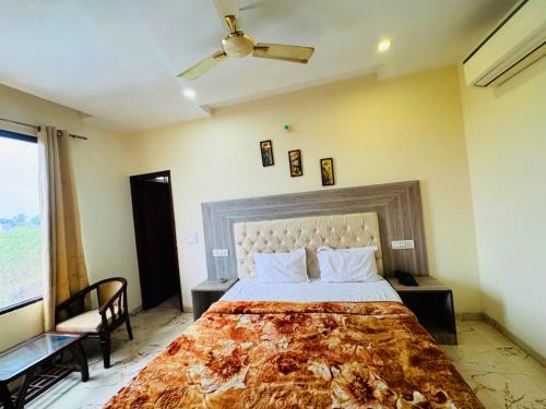 a bedroom with a large bed and a ceiling fan at Hotel tree inn in Zirakpur
