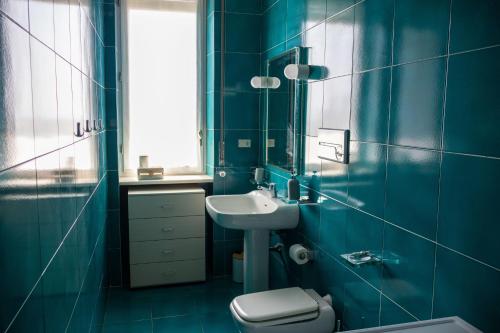 Un baño azul con lavabo e inodoro. en Holiday Home Junior Giacomelli, en Mati
