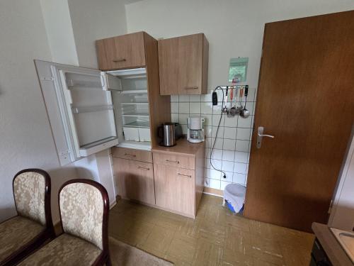 a small kitchen with wooden cabinets and a refrigerator at Ferienwohnung mit Balkon und Stadtnähe in Bad Sachsa