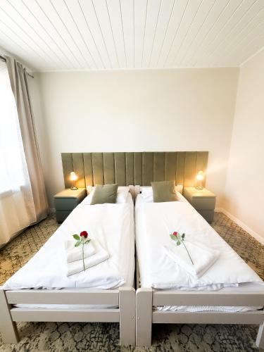 a bedroom with two beds with flowers on the pillows at VILLA SUNNY ROSE Bed & Breakfast in Świnoujście