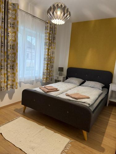 a bed in a bedroom with a large window at BellaRóza in Solt