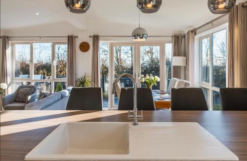 a kitchen with a sink and a living room at Luxury lodge - St Helens in Isle of Wight