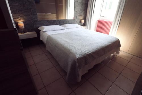 a bedroom with a large bed and a window at Hotel Pontenuovo in Merone