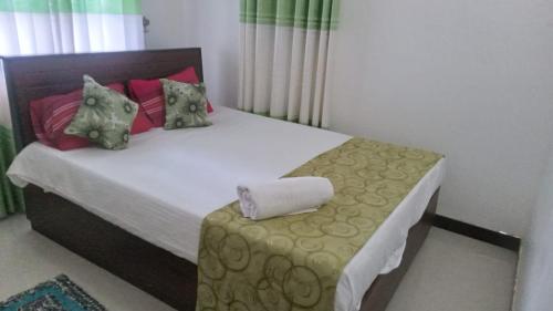 a small bedroom with a bed with a pillow on it at Coconut Villa Homestay in Habarana