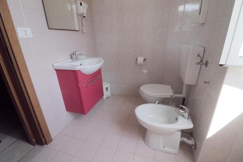 a bathroom with a white toilet and a sink at Hotel Pontenuovo in Merone