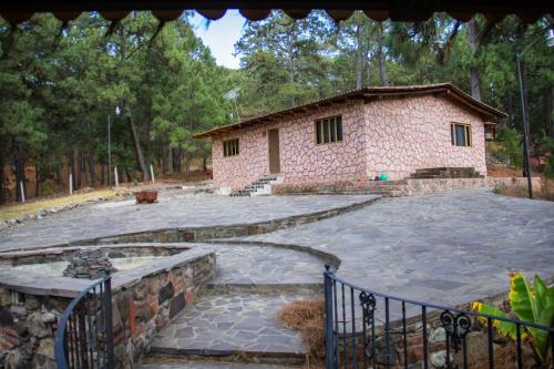 a building with a stone patio in front of it at Cabañas RuizSeñor in Mazamitla