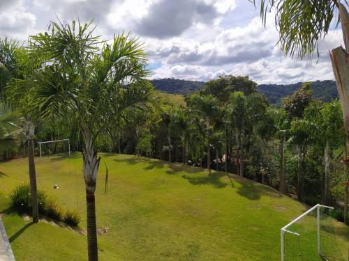 a lawn with a palm tree in a field at Casa Versos in Nova Lima