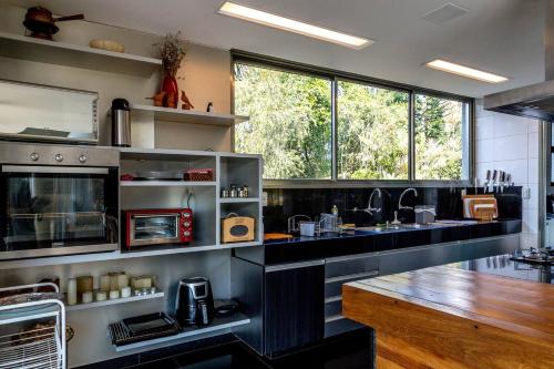 a large kitchen with black counters and a large window at Casa Versos in Nova Lima