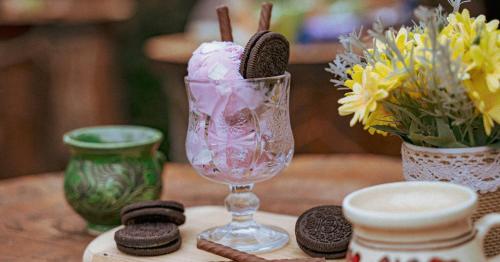 a table with a wine glass with cookies and flowers at Hanul Ceaunelor Voronet in Voronet