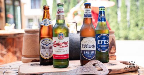 four bottles of beer sitting on a table at Hanul Ceaunelor Voronet in Voronet